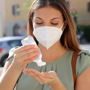 Mujer aplicándose alcohol gel