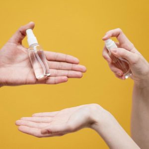 personas aplicándose alcohol líquido para desinfectar sus manos