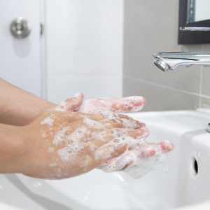 persona lavándose las manos con el jabón germicida